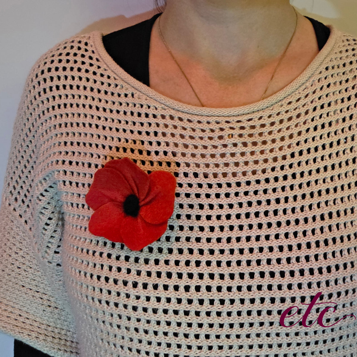 A person wearing an Anzac Poppy brooch