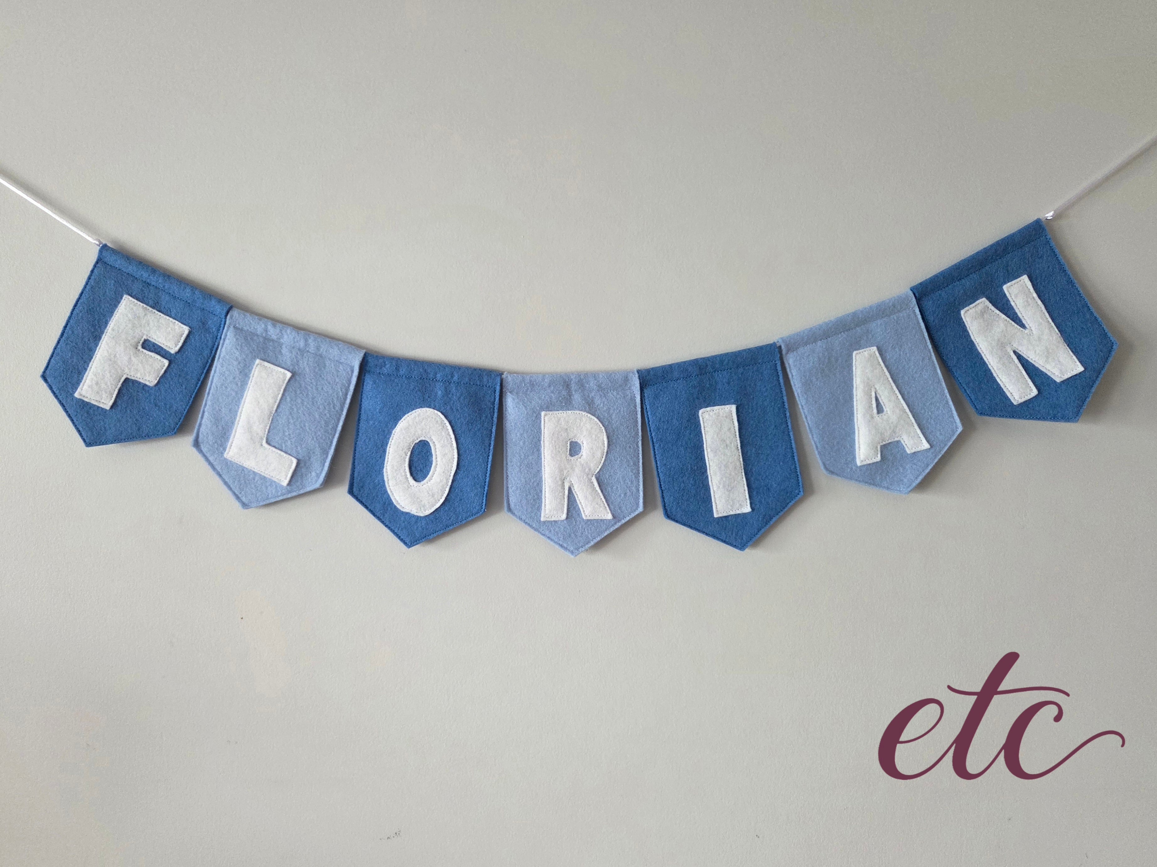 Felt banner with 'FLORIAN' on a plain background