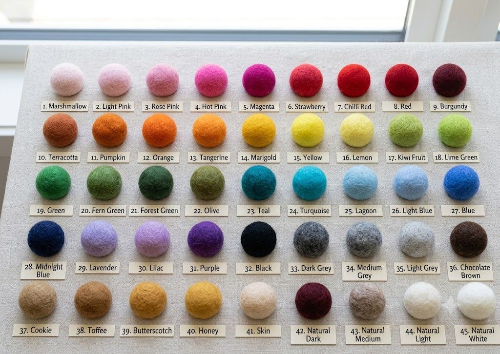 Color swatch chart with various colored felt bualls on a white background