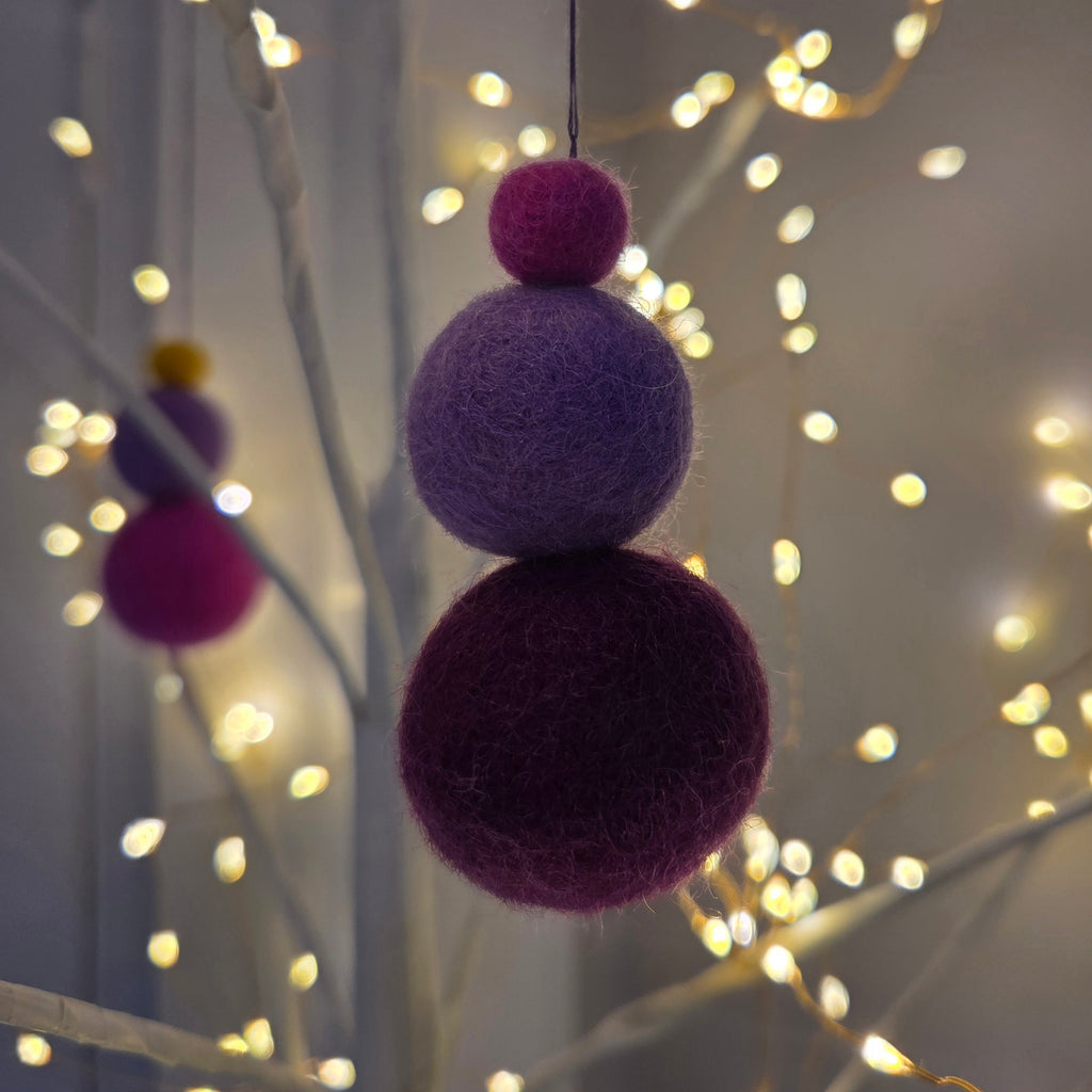 Close up of felted fragnance balls in a light tree