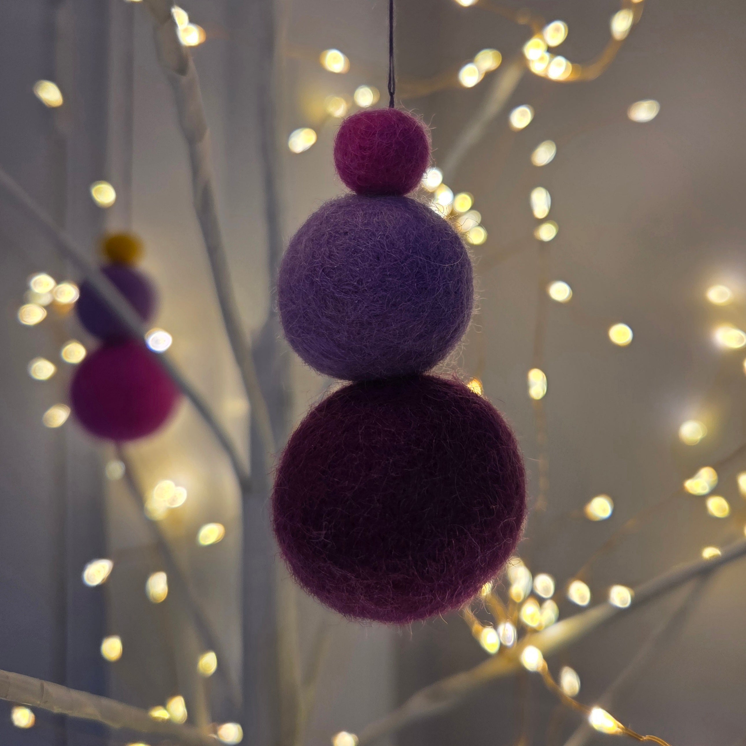 Close up of felted fragnance balls in a light tree