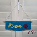 Blue felt banner with 'Mason' and a red paw print on a white background