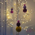 Fragnance balls, with 3 various sizes in a tree with lights
