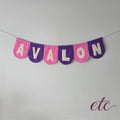 Personalised felt bunting / garland with 'Avalon' letters on a plain background