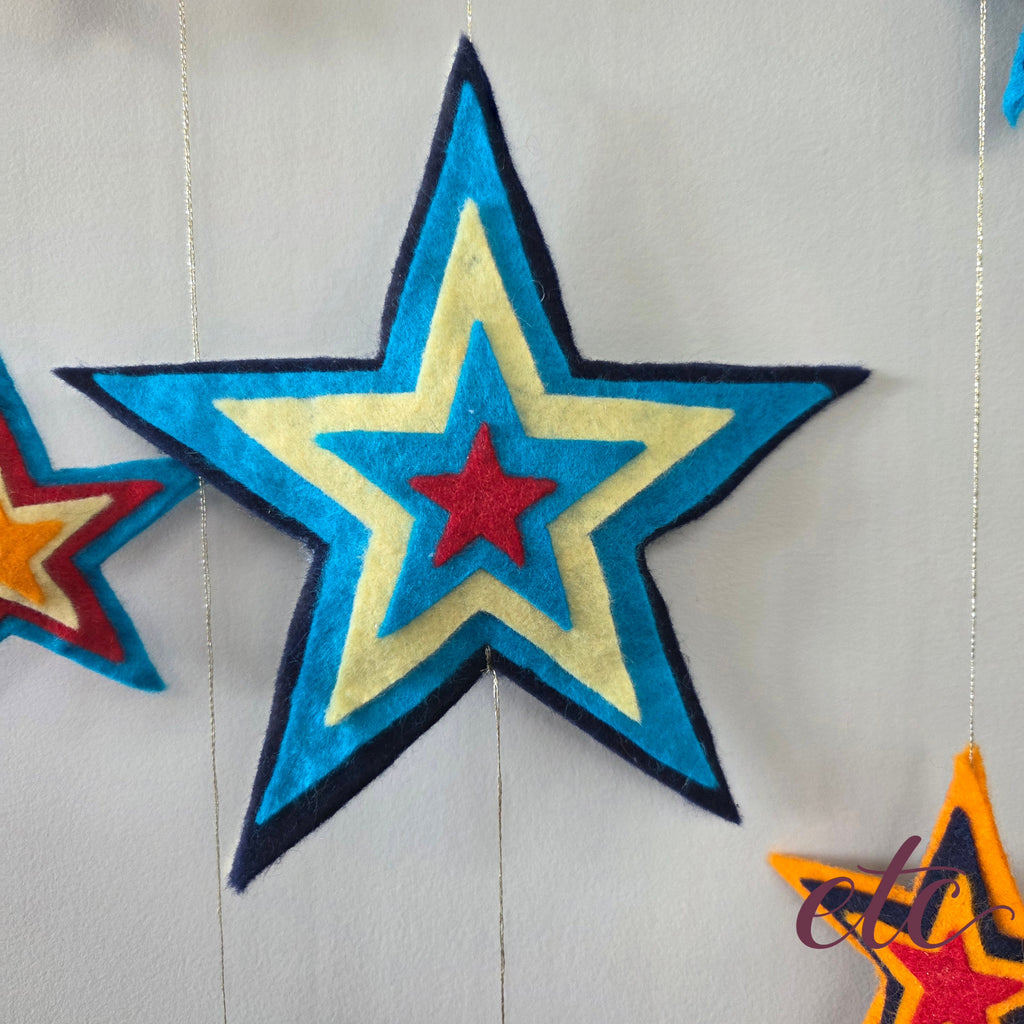 Large felt start with different layers going from dark blue, turqoise, yellow, turqoise, red