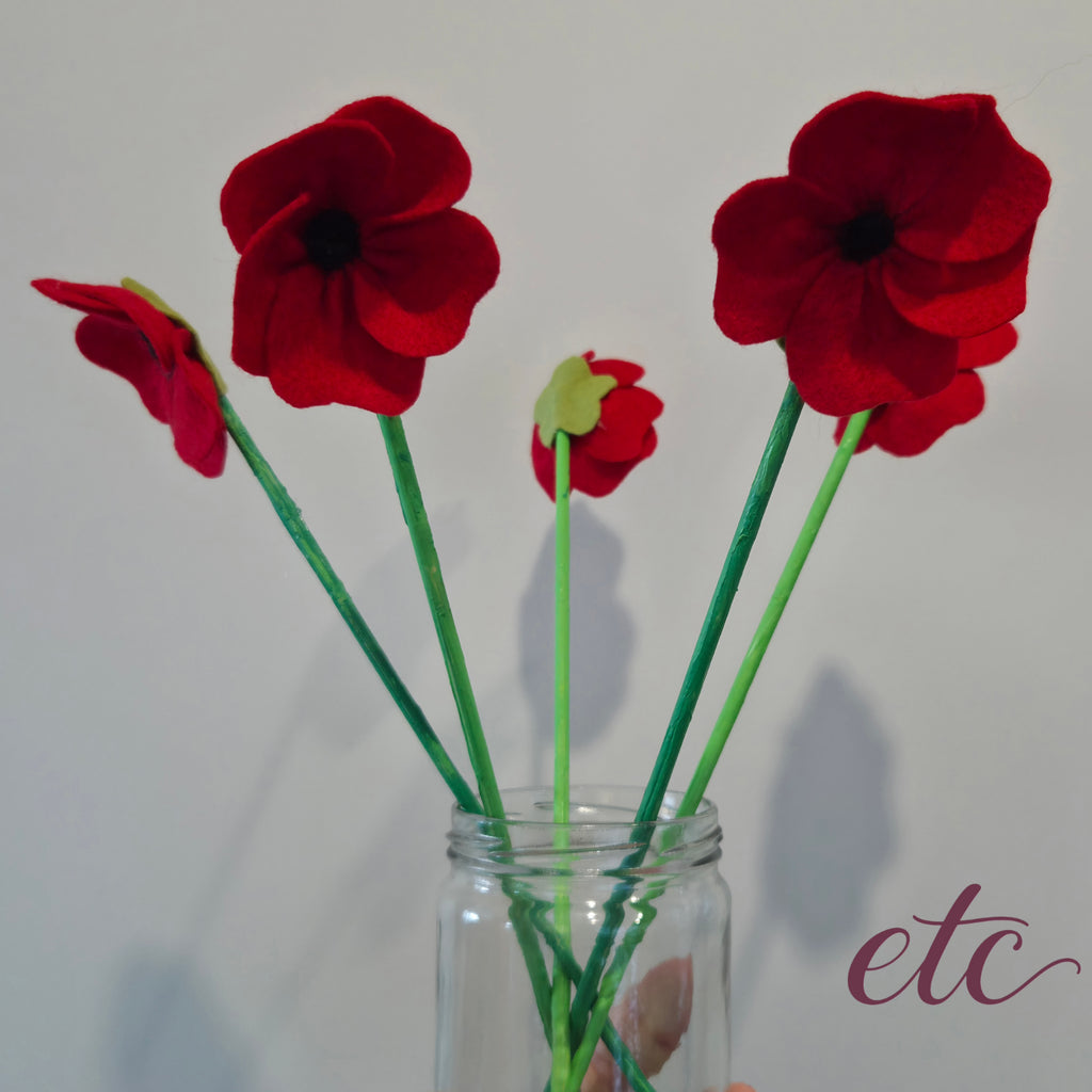 Red vibrant poppies on green sticks
