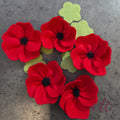 Red vibrant poppies with a black felted heart and green setals