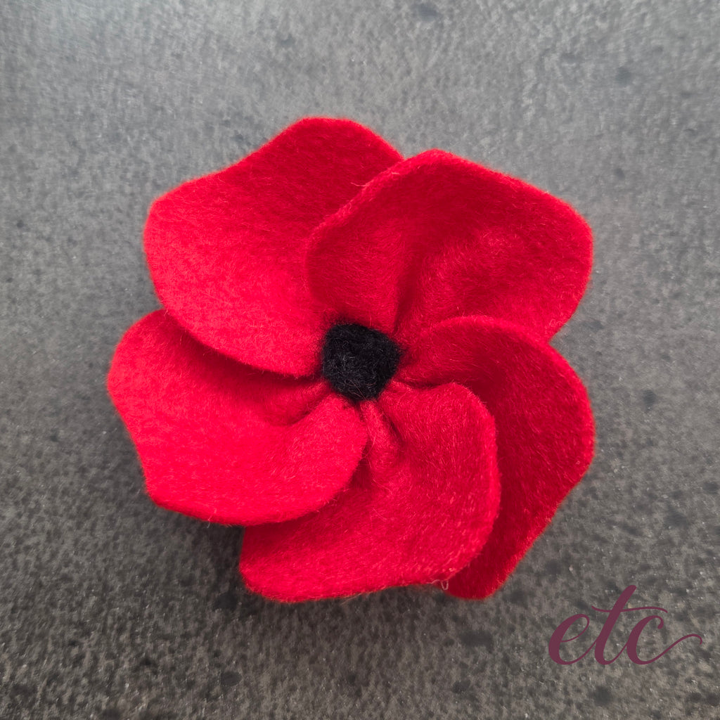 vibrant red felt poppy with a black needle felted hear